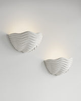 Clam Sconce paired installation, light-on view, two resin wall sconces