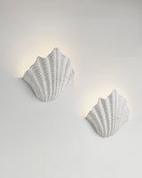 Cove Sconce paired installation, lit view, two resin wall sconces